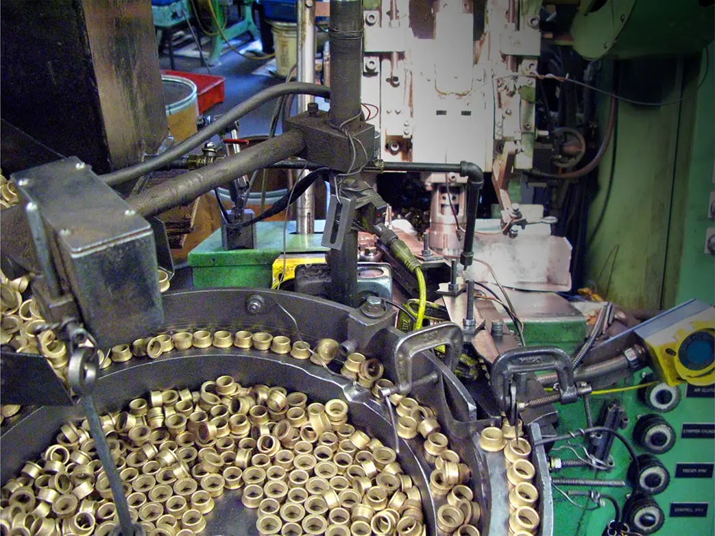 Sized bronze bearings in the feed of a sizing press at Symmco